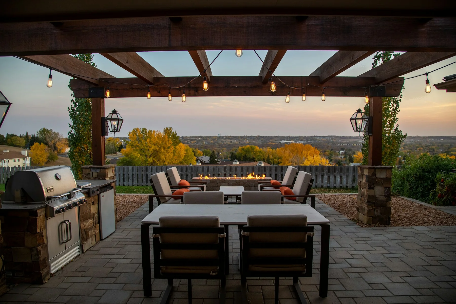 Timber pergola with an outdoor kitchen, masonry post bases and a hillside view
